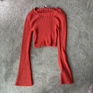 cropped, ribbed knit sweater in a vibrant orange-red color
